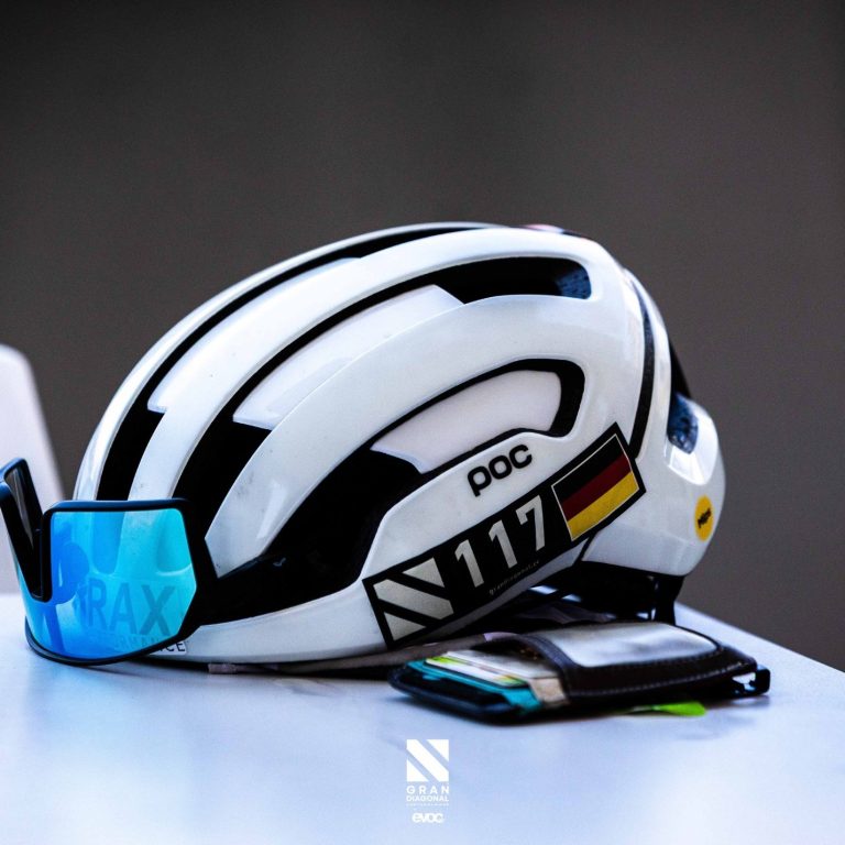 Weißer Fahrradhelm mit blauen Sonnenbrille und Tasche, gekennzeichnet mit der Nummer 117.